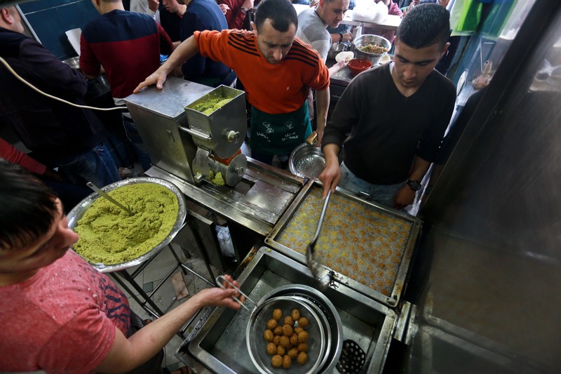 Aerial view of three men working at falafel frying station