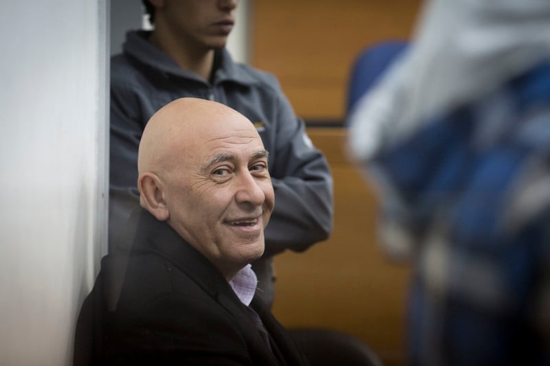 Basel Ghattas smiles at camera while sitting down in courtroom
