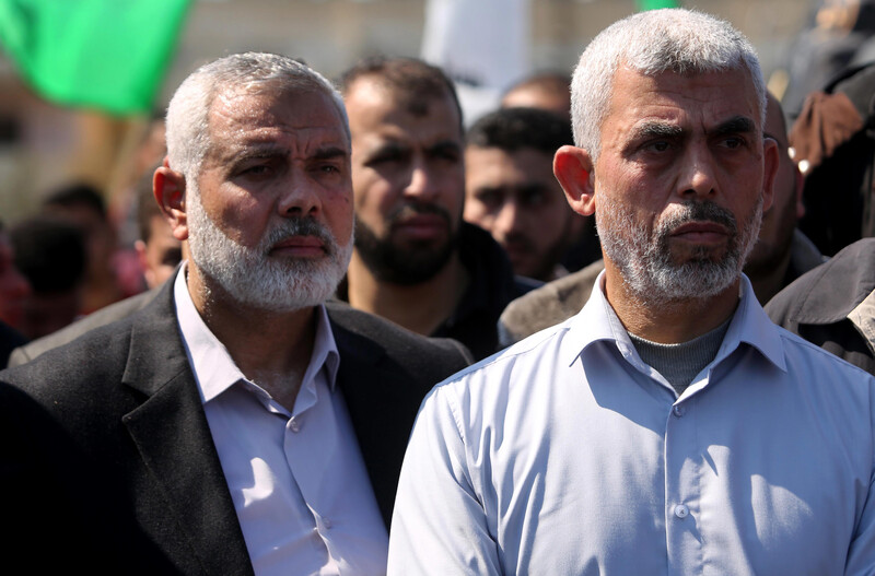 Ismail Haniyeh and Yahnya Sinwar are seen from chest up standing next to each other during Mazen al-Fuqaha's funeral