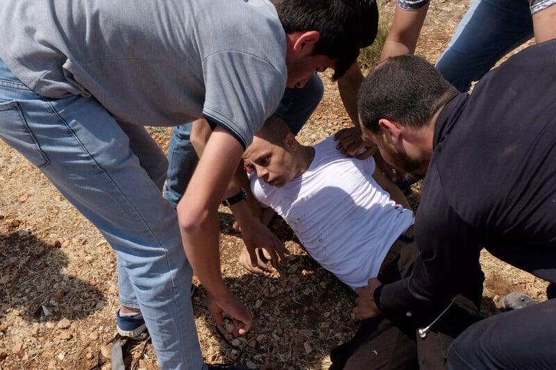 Group of youths come to aid of young man who is injured in the ground