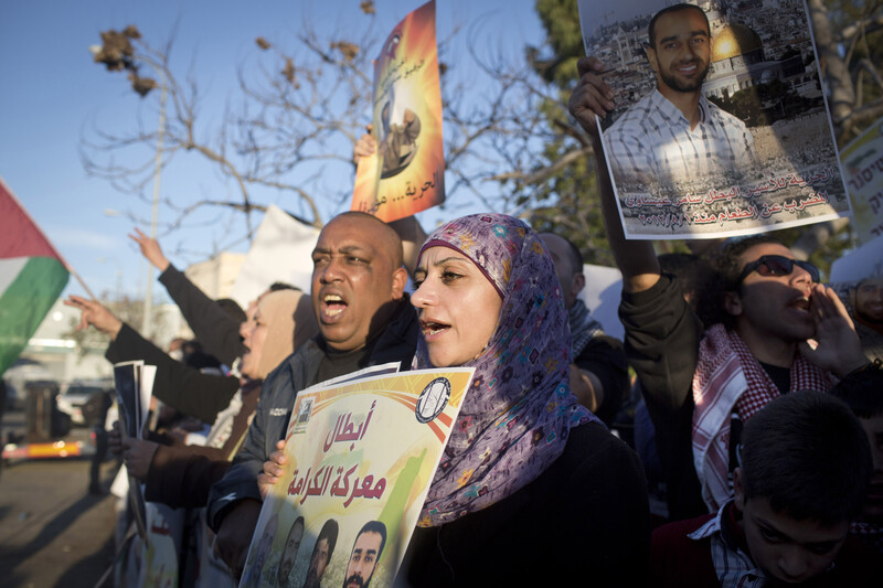 Young woman holds a poster in a crowd of protesters