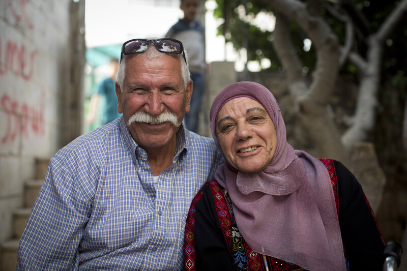 Smiling couple looking at camera are seen from chest up