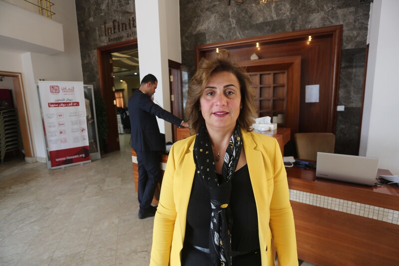 Mona Adnan Ghalayini stands in front of reception desk