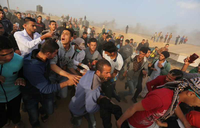 Crowd of protesters carry injured man