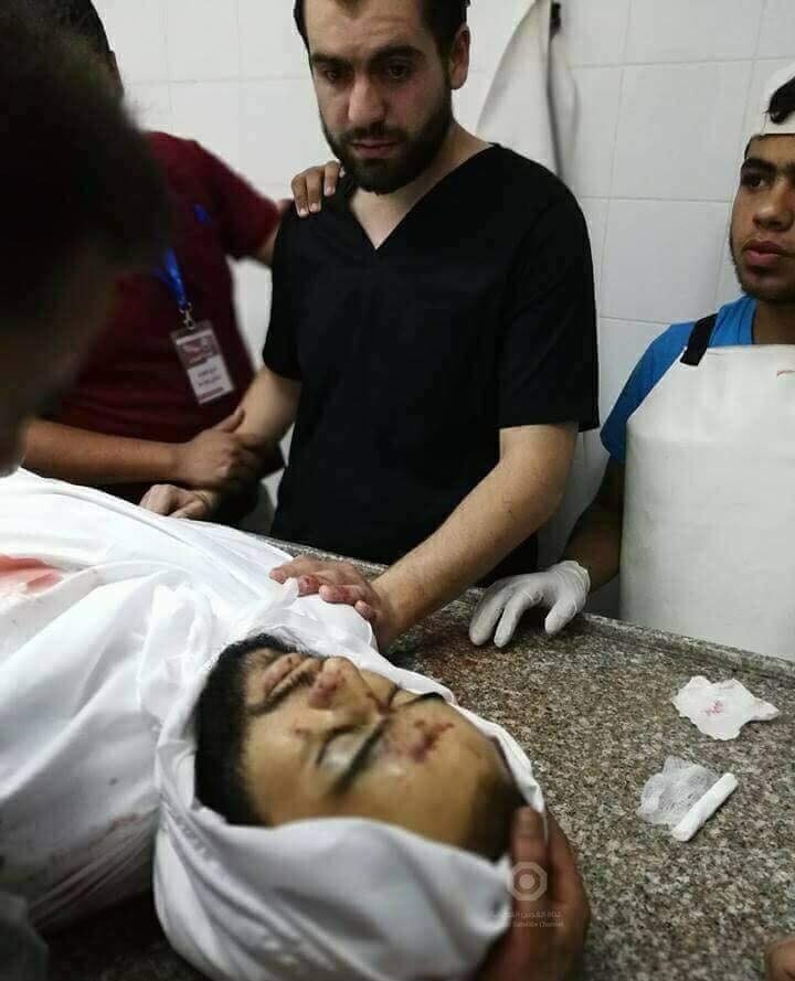 Standing man looks at a shrouded body lying on a table