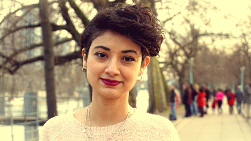 Portrait of young woman standing in urban area