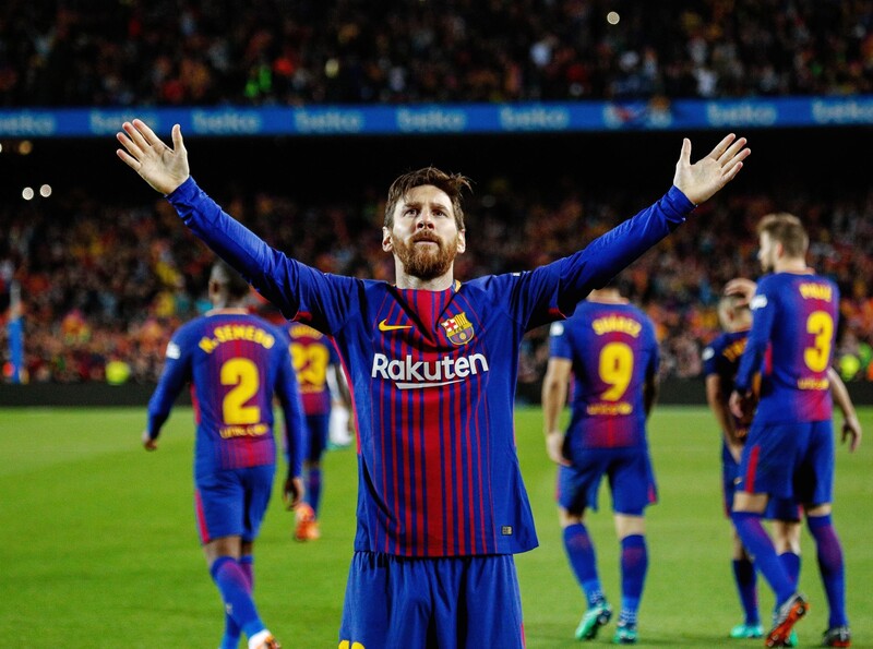Man on football field raises his arms above his head