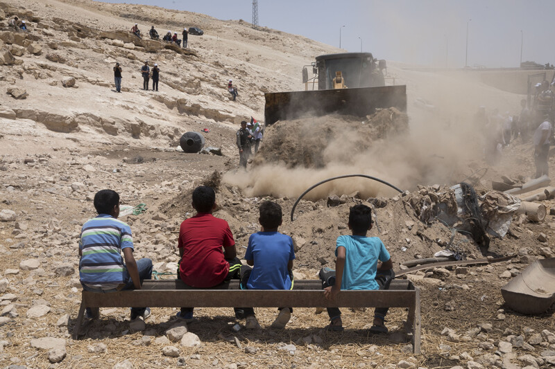 Palestinian children watching an Israeli bulldozer 