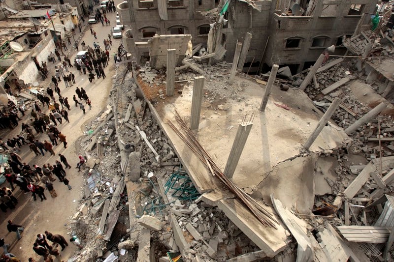 People stand next to the rubble of a mosque in Jabaliya refugee camp. The mosque was destroyed in a missile strike during Israel's 2008-09 war on Gaza
