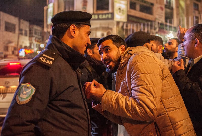 A demonstrator protesting a new Palestinian social security law remonstrates with a policeman in Ramallah. 