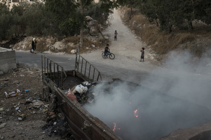 Rubbish burns in a dumpster.