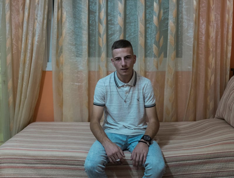 Ali Aleyeh sits on his bed. 