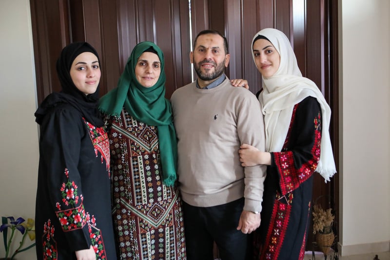 Imad al-Din stands surrounded by his wife and two daughters