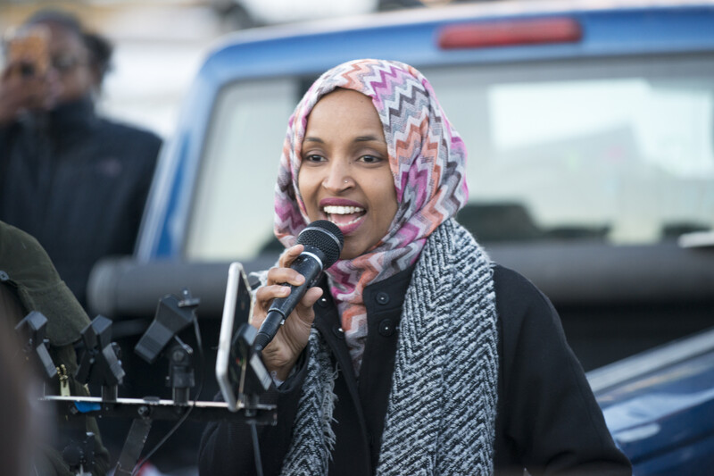 Representative Ilhan Omar speaks into a microphone.