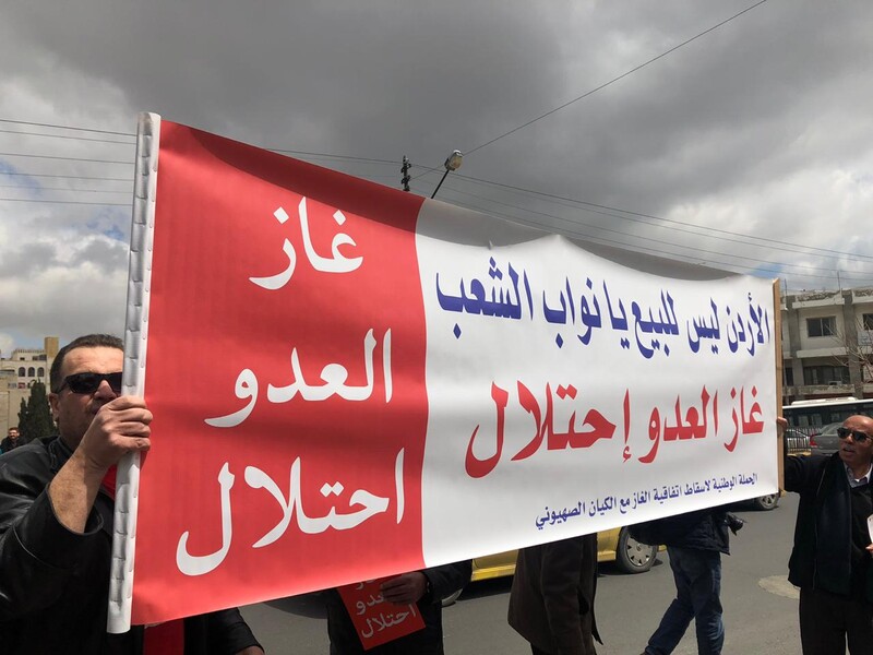 Two men hold up a large banner. 