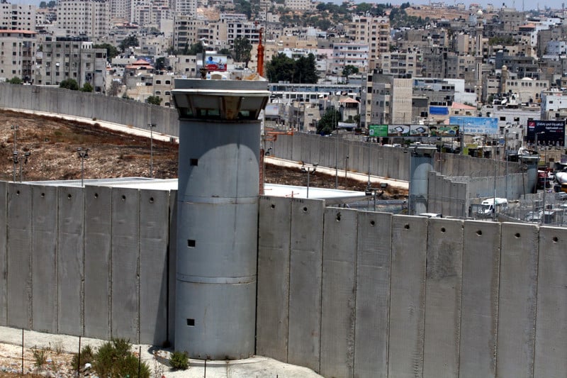 An Israeli watchtower looms over Palestinian houses in the occupied West Bank