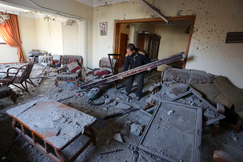 Man carries a beam in a living room covered with dust