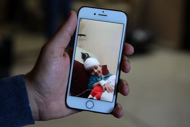 A picture on a mobile phone shows a bandaged girl smiling