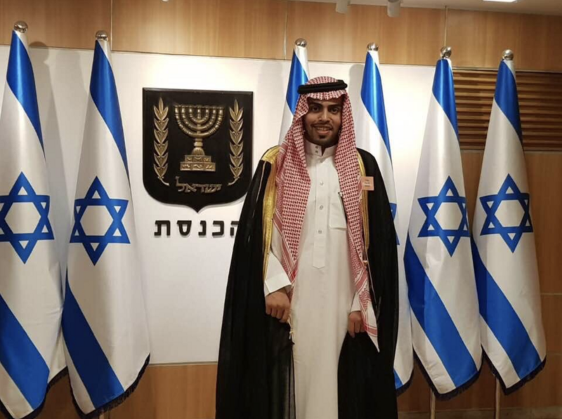 Man stands in front of Israeli flags 