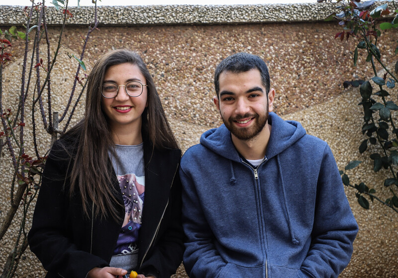 A young man and woman smile at the camera 