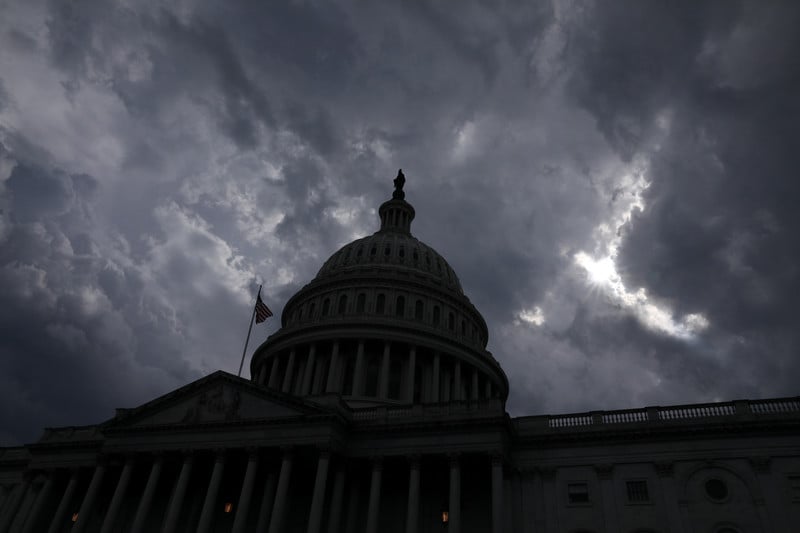 Dome of US Capitol against stormy sky