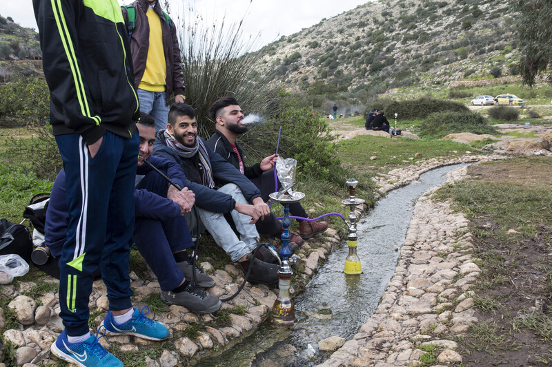 Young men smoking shisha at stream