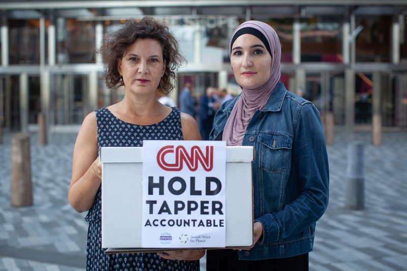 Two women hold sign