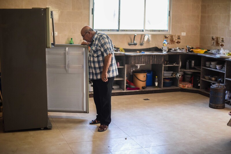 Man opens refrigerator door in spacious kitchen