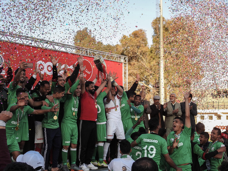 Footballers stand on stage as confetti falls on them