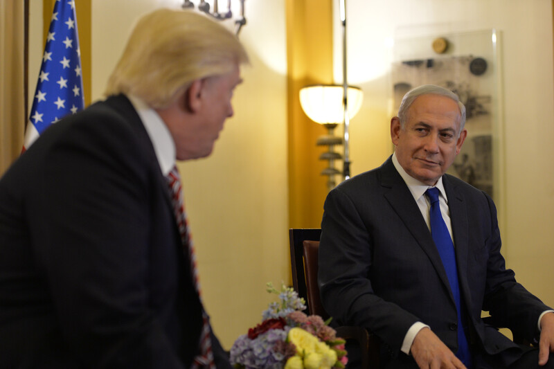 Two men sit in chairs talking