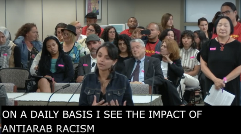 A woman stands at a microphone