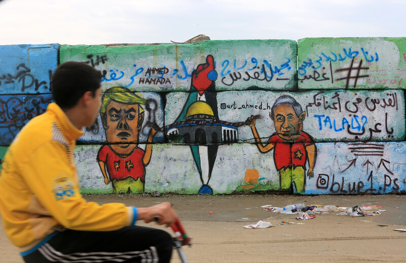 A boy looks at graffiti on a wal