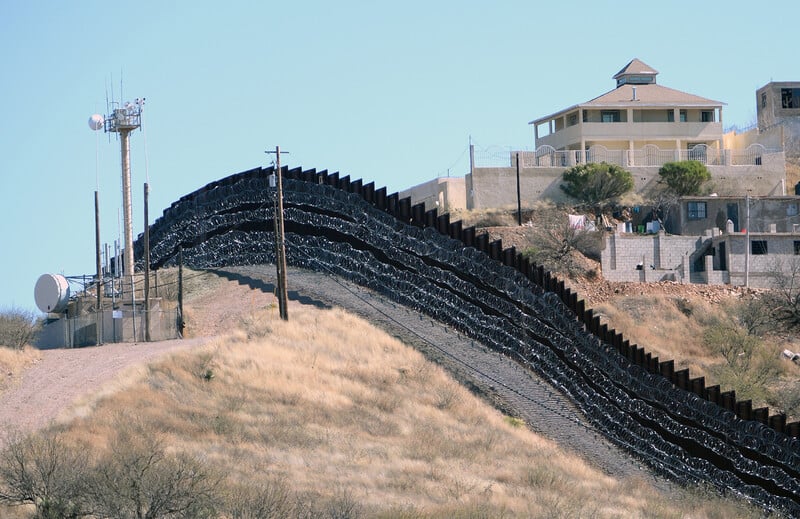 A wall and a surveillance tower in front of a house