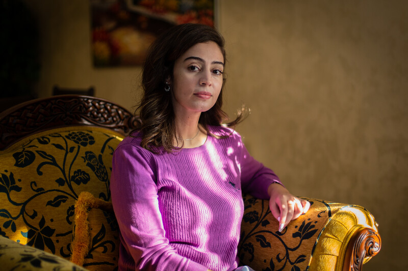 Woman sits on a cushioned chair 