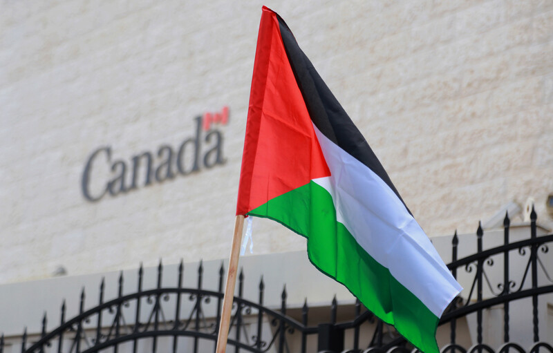 A flag flies in front of a building