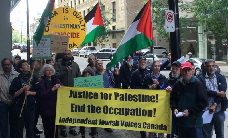 Demonstrators wave Palestinian flags and hold signs