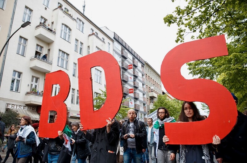 People march in demo carrying signs supporting Israel boycott