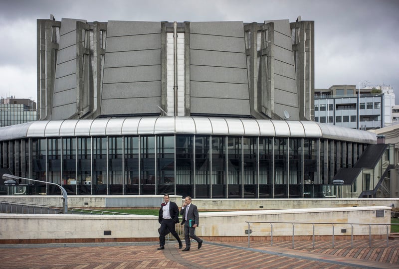 Two men walk in front of a modern building