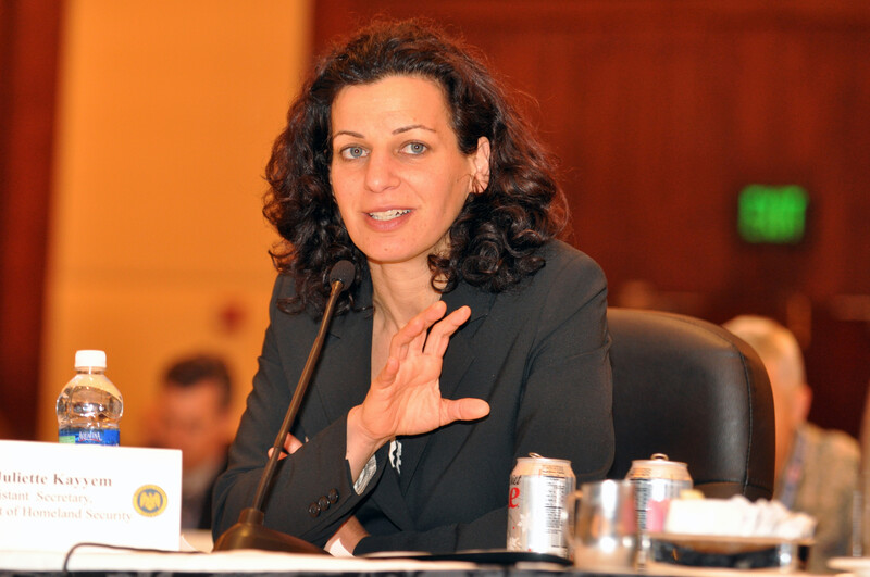 Woman in suit sits near microphone 