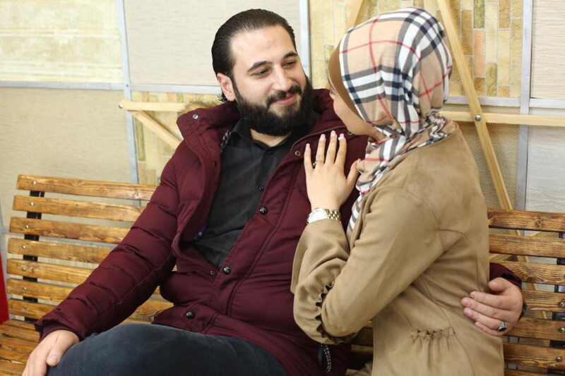 A young couple face each other on a couch