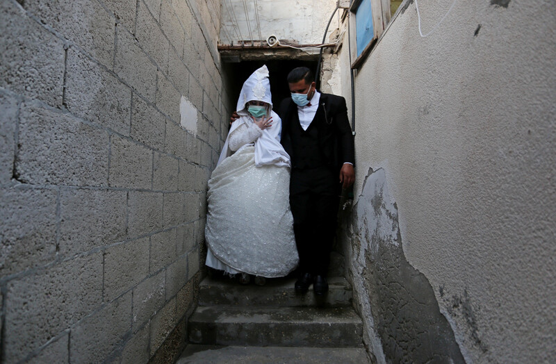 Woman in wedding dress and man in suit stand on steps