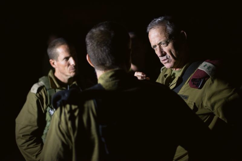 Three men in military uniforms converse