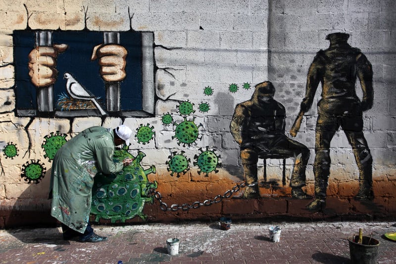 Man spray painting graffiti on a wall