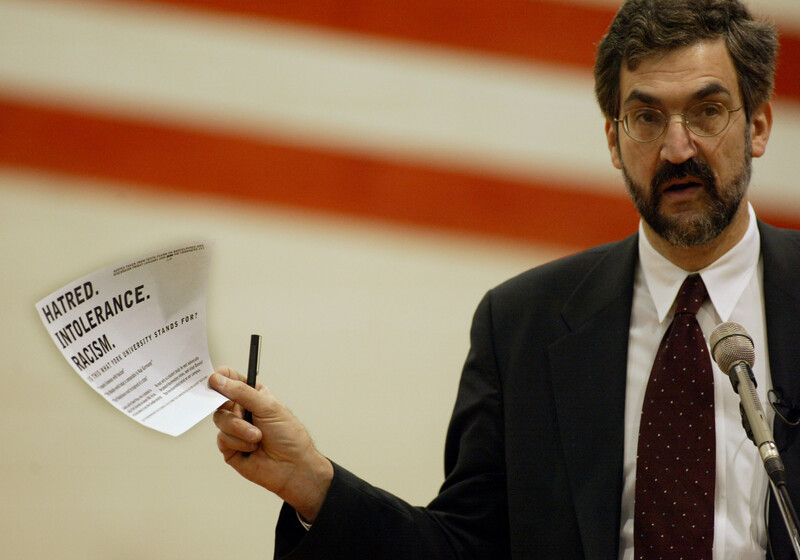 Man stands with paper and pen in hand