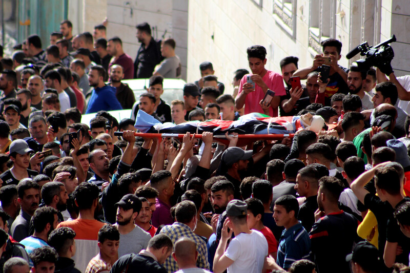 People carry body on a stretcher 