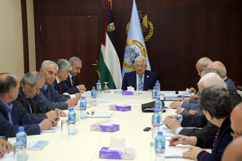 People in suits sit around a table