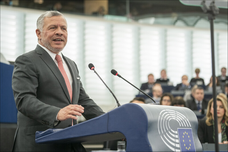 Man in suit standing before podium
