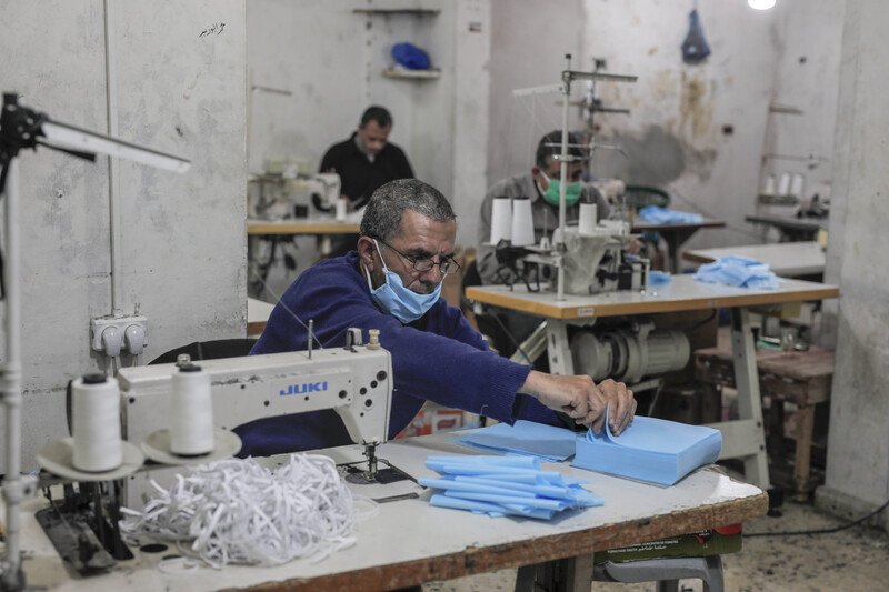 Men sewing protective face masks