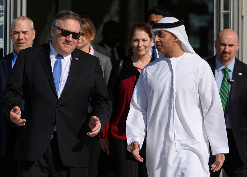 Two men walking and talking with others