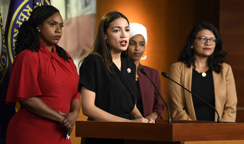 Four women stand at podium